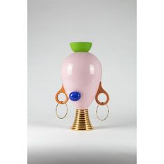 a pink vase sitting on top of a metal stand with scissors attached to the base