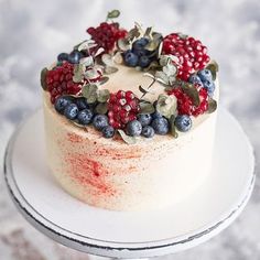 a white cake topped with berries and blueberries