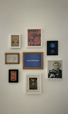 a wall with many different framed pictures on it's side, including one for the album cover