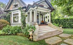 a house that is in the grass with steps leading up to it's front door