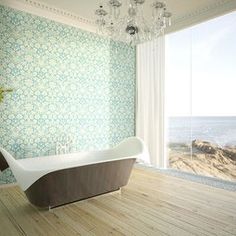 a bathroom with a tub, chandelier and large window overlooking the ocean is pictured in this image