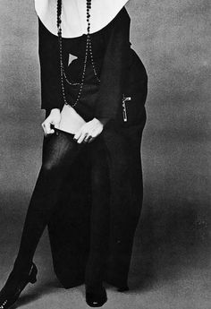 a woman in black and white is posing for a photo with her hands on her hips