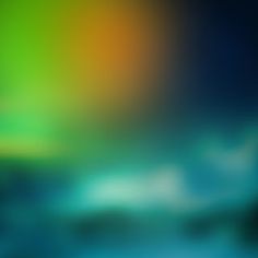 blurry image of the sky and water with green, orange, yellow and blue colors