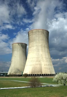 two cooling towers in front of a cloudy sky