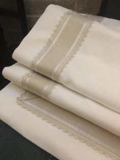 three folded sheets with white lace on them