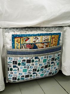 a close up of a bed with a pillow on top of it and a book in the pocket