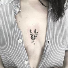 a woman's chest with a small flower tattoo on the left side of her chest