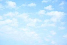 a group of people standing on top of a lush green field under a blue sky