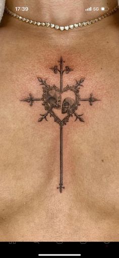 a cross with skulls on it is shown in this tattoo style photo taken from the chest