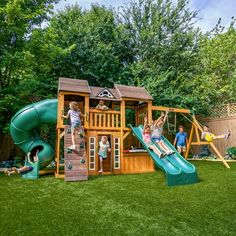 children playing in the backyard on a wooden play set with slide and climbing wall,