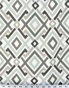 a white and gray fabric with an abstract design on it's side, next to a ruler