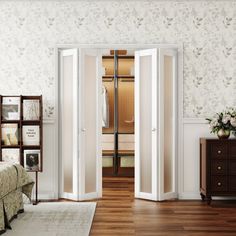 an open door leading into a bedroom with white walls and wood floors, along with a bed