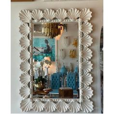 a mirror that is sitting on top of a wall next to a shelf with vases and other items