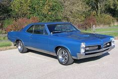 a blue muscle car parked in a parking lot