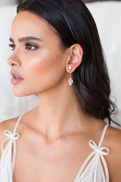 a woman wearing earrings with bows on the back of her head and shoulder, looking off to the side