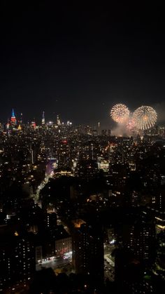 fireworks are lit up the night sky over a cityscape with skyscrapers in the background