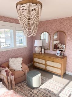 a living room with pink wallpaper and a chandelier hanging from the ceiling