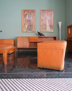 a living room filled with furniture and paintings on the wall