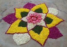 a colorful flower made out of flowers on top of a green surface with red, yellow and white colors