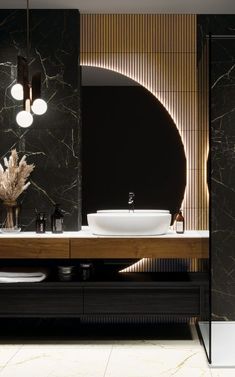 a modern bathroom with black marble walls and flooring, two sinks on the counter