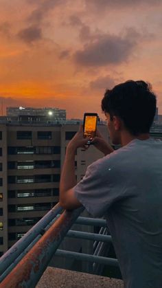 a man standing on top of a building while looking at his cell phone