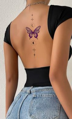 the back of a woman's body with a butterfly tattoo on her lower back