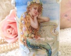 a close up of a cup with a mermaid on it