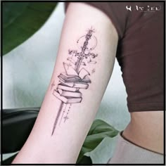 a woman with a tattoo on her arm holding a book and a cross in it