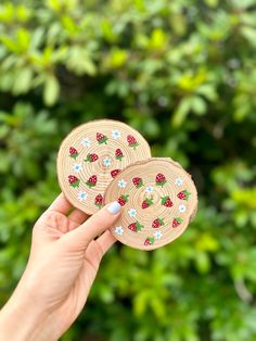 two wooden coasters with ladybugs on them in front of some bushes and trees