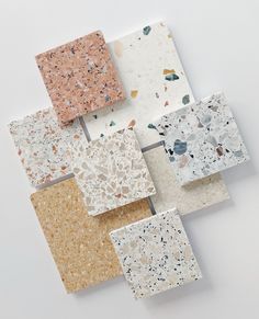 several different colors and shapes of tiles on a white surface with small speckles