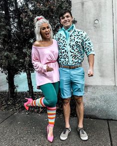 the man and woman are dressed up in colorful outfits, posing for a photo together