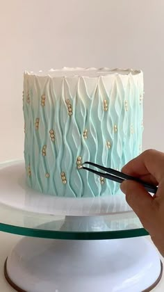 a person cutting into a cake with a pair of scissors on top of the cake