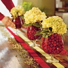 strawberries and flowers are arranged in vases