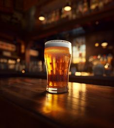 a glass of beer sitting on top of a wooden table