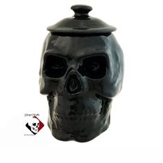 a black ceramic skull with a lid on it's head is shown in front of a white background