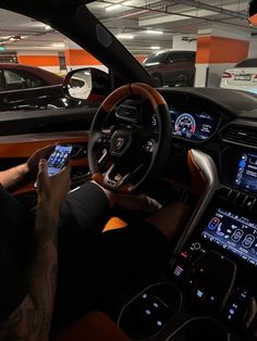 a man sitting in the driver's seat of a car using his cell phone