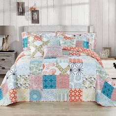 a bed covered in colorful patchwork quilts and pillows