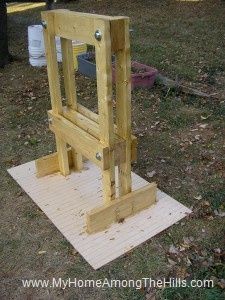 a wooden frame sitting on top of a piece of plywood in the middle of a yard