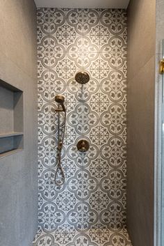 a walk in shower sitting inside of a bathroom next to a tiled wall and floor