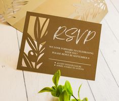 a brown and white wedding card with the word rsp printed on it next to a potted plant