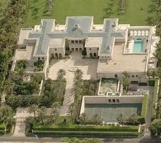 an aerial view of a large mansion with pool and tennis court in the foreground