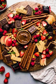 a platter filled with chocolate, strawberries and crackers on top of a table