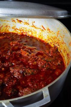 a pot filled with meat and sauce on top of a stove