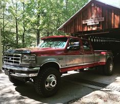 a red truck parked in front of a wooden cabin