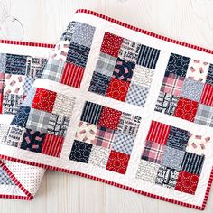 two red, white and blue quilted placemats sitting on top of each other