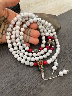 Beautiful Howlite Mala from Nepal and Mountain shell beads Mala necklace. You can choose between the mala that is made with howlite beads (white with gray) and mix metal beads from Nepal, or the all white mala necklace, which is made with mountain shell beads and a yellow mantra symbol. A unique praying mala that can be used as a necklace or as an ornament. The mala has no clasp, you wear it over the head. --The Mala with the metal beads and the red beads has a total length of 48.2cm- 19 inch lo Buddhist Mala, Wiccan Necklace, Yoga Lover Gift, Beads Mala, 108 Mala Beads, Mens Necklace, Red Beads, Yoga Gifts, Skull Necklace