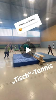 a group of people in a gym playing frisbee on a trampoline