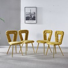 three yellow chairs sitting next to each other in front of a plant on the floor