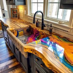 a kitchen counter with an artistic design painted on the counter top and below it is a sink in front of a window