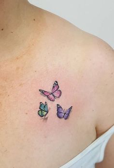 three colorful butterflies on the back of a woman's upper arm and shoulder tattoo